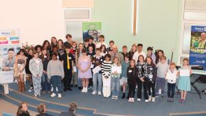 The thirty-five Young Musicians surrounding President Clive Livingstone.